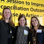Photo taken during the Together25Ensemble conference featuring three women posing in front of a yellow background